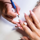 Nail technician applying gel nail polish
