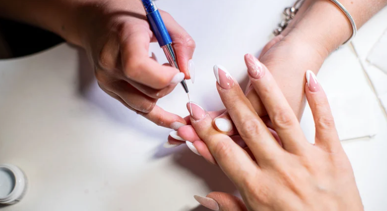 Nail technician applying gel nail polish